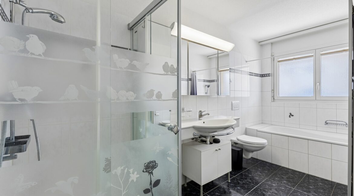 Praktisches Badezimmer mit Badewanne, Dusche und Tageslicht