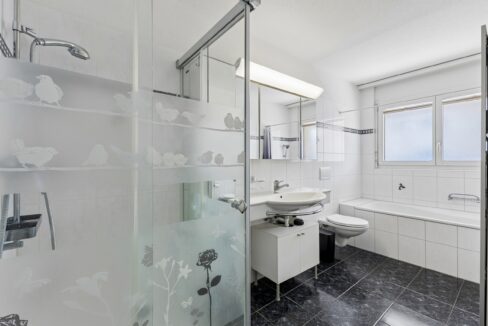 Praktisches Badezimmer mit Badewanne, Dusche und Tageslicht