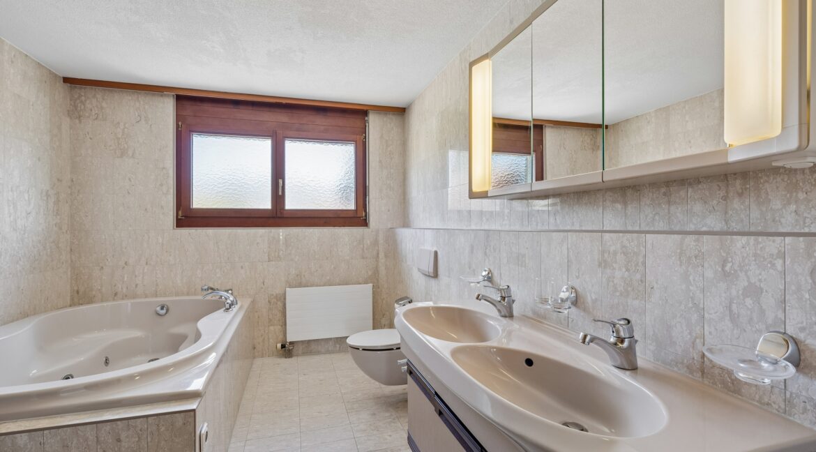 Badezimmer mit Doppellavabo und einladender Whirlpool-Badewanne (1.OG)