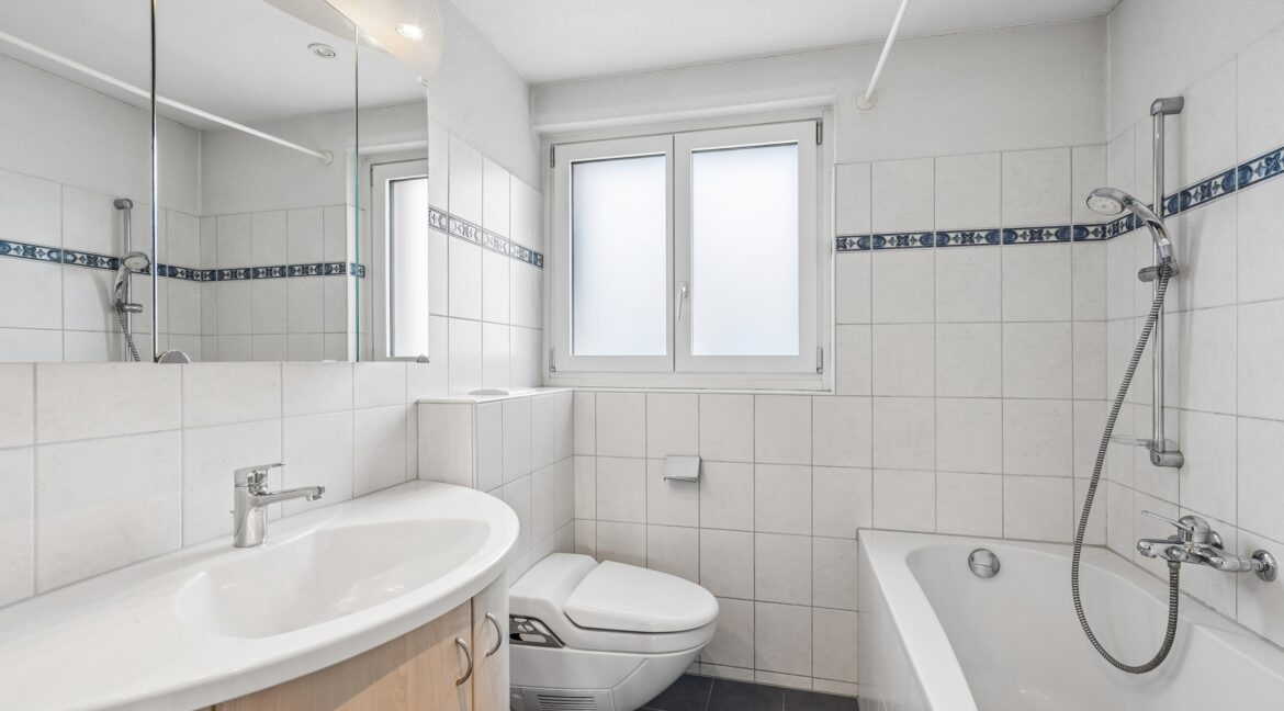 Obergeschosswohnung: Badezimmer mit Badewanne, Fenster und viel Stauraum