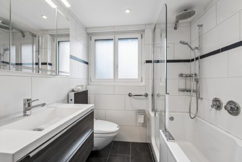 Erdgeschosswohnung: Komfortables Badezimmer mit Badewanne, Dusche, Schränken und Tageslicht